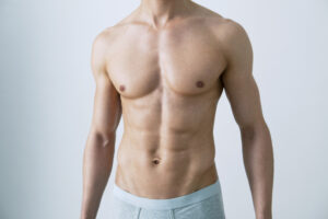 Male torso showing defined chest contours related to silicone pectoral implants and male chest enhancement