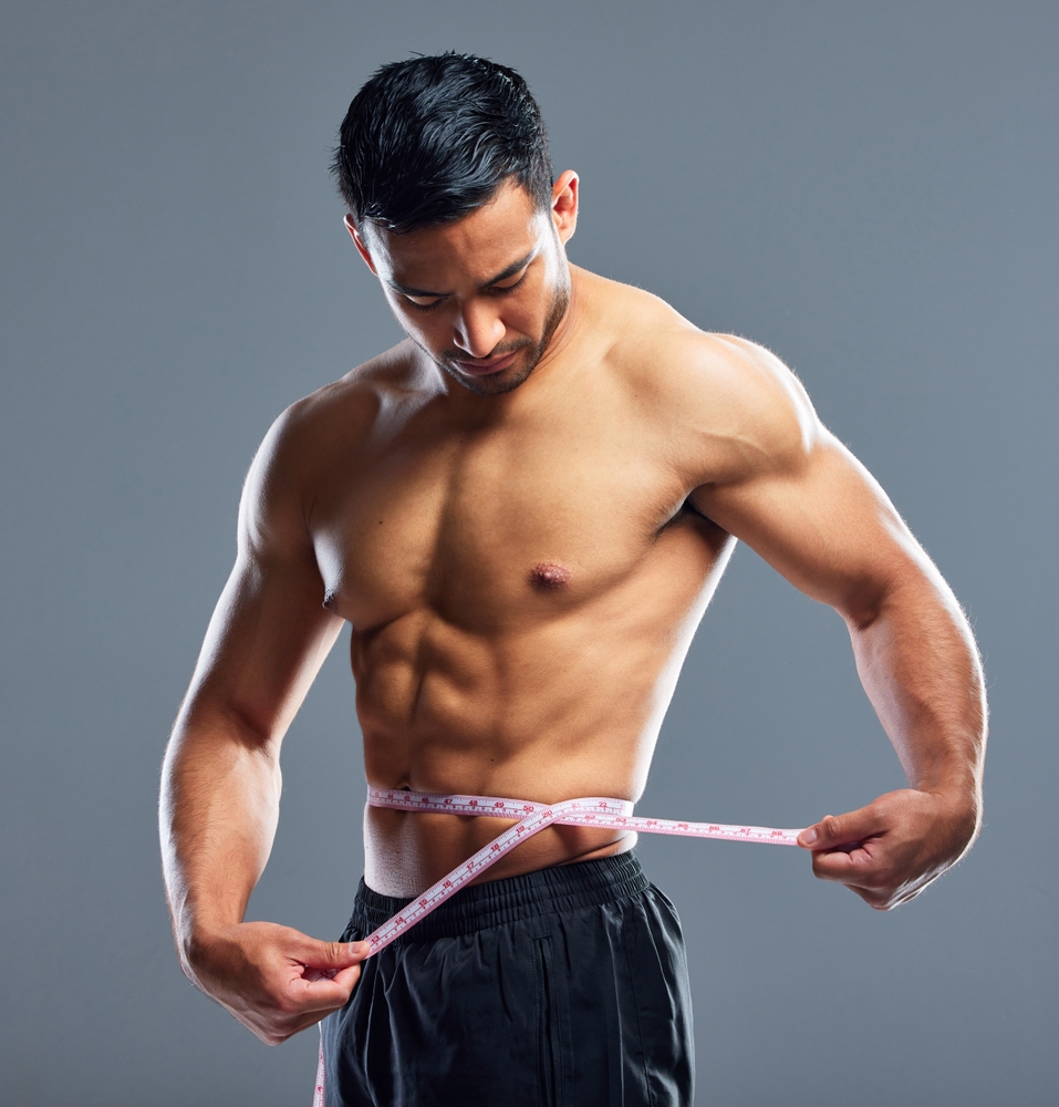 Athletic man measuring his waist beside text about hi-def liposculpting for male waist contouring