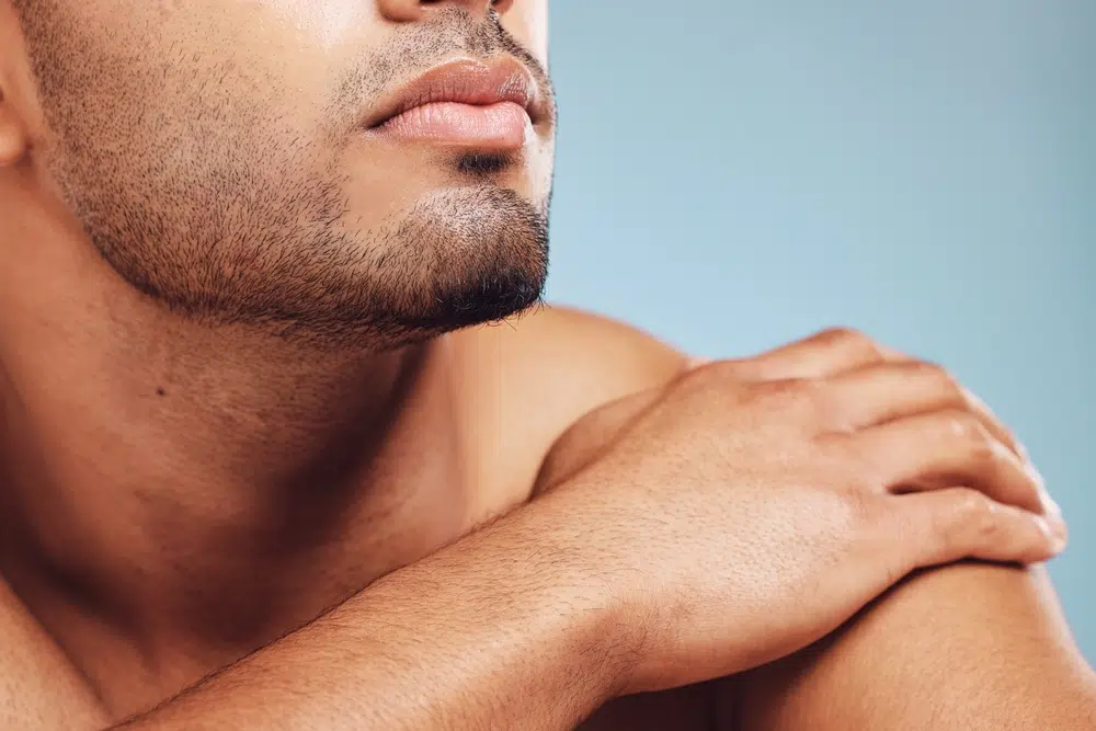 Close-up of male jawline beside candidate criteria for male jawline recontouring and facial definition.